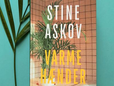 Foto af Stine Askovs bog "Varme hænder", der ligger ovenpå et blad